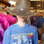 Trying on a cowboy hat and hiding her face. 2019-07-29 Back _Yard Elk